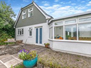 a home with a large window and a patio at Primrose Cottage in Poundstock