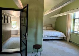 Dormitorio con cama y puerta de cristal que da a una habitación en Exclusive Castle Gatehouse Österlen, en Tomelilla