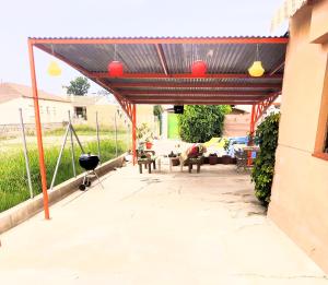 d'une terrasse avec un auvent, des tables et des chaises. dans l'établissement EBREHOME, à Deltebre