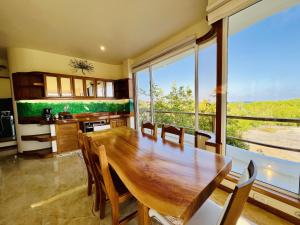 Blue Heron Galápagos Villa في بويرتو أيورا: غرفة طعام مع طاولة خشبية ونافذة كبيرة