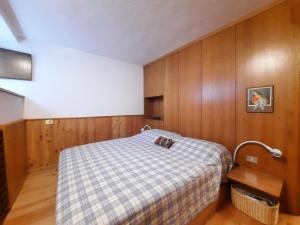 a small bedroom with a bed and wooden walls at TRILOCALE PANORAMA VISTA MONTE BIANCO in Courmayeur