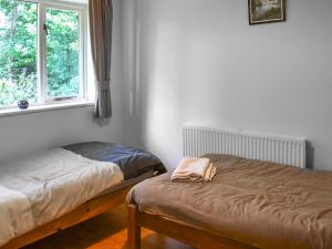 a bedroom with two beds and a window at Woodside Fishery - The Mallards in Cleobury Mortimer