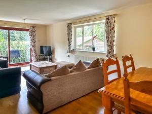 a living room with a couch and a table at Woodside Fishery - The Mallards in Cleobury Mortimer