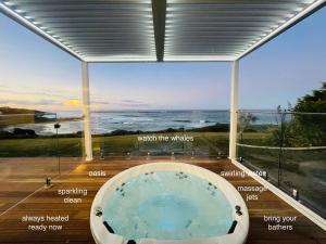 a bath tub in a room with a view of the ocean at Saltwater - Absolute Oceanfront, Hot Tubs, Sauna, Fire Pits in Falmouth