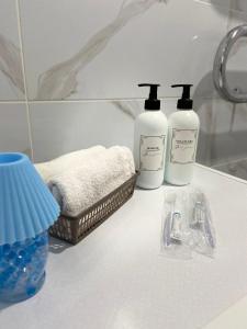 - deux bouteilles de savon et des serviettes sur un comptoir de salle de bains dans l'établissement микрорайон Астана с кодовым замком, à Uralsk