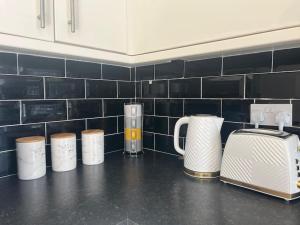 a kitchen counter with four coffeemakers and a toaster at CAPRI 13 SA- Nice ’n’ New, close to Uni and M1/J23 in Loughborough