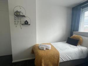 a bedroom with a bed with a blanket and a window at CAPRI 13 SA's 3 bedroom home, close to Loughborough University and M1 in Loughborough