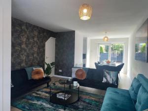 a living room with two blue couches and a table at CAPRI 13 SA's 3 bedroom home, close to Loughborough University and M1 in Loughborough