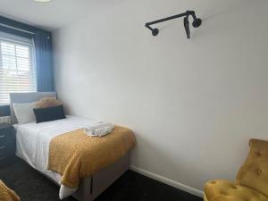 a bedroom with a bed and a chair in a room at CAPRI 13 SA's 3 bedroom home, close to Loughborough University and M1 in Loughborough