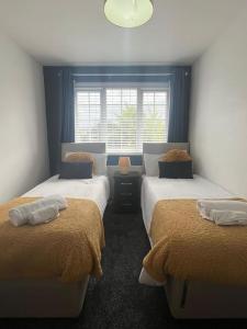 - une chambre avec 2 lits et une fenêtre dans l'établissement CAPRI 13 SA- Nice ’n’ New, close to Uni and M1/J23, à Loughborough