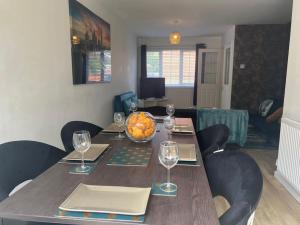 a dining room table with a bowl of fruit and wine glasses at CAPRI 13 SA's 3 bedroom home, close to Loughborough University and M1 in Loughborough