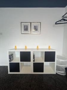a white cabinet with two shelves in a room at CAPRI 13 SA's 3 bedroom home, close to Loughborough University and M1 in Loughborough