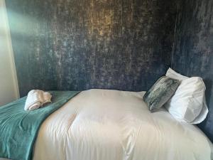 a bed with two pillows and a wall at CAPRI 13 SA's 3 bedroom home, close to Loughborough University and M1 in Loughborough