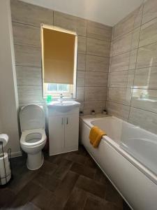 a bathroom with a toilet and a tub and a sink at CAPRI 13 SA's 3 bedroom home, close to Loughborough University and M1 in Loughborough
