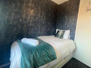 a bedroom with a bed with a green accent wall at CAPRI 13 SA's 3 bedroom home, close to Loughborough University and M1 in Loughborough