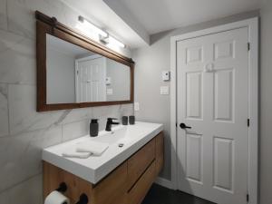 a bathroom with a white sink and a mirror at Chalet Détente Orford in Orford
