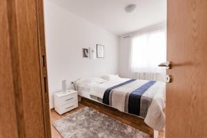 um quarto branco com uma cama e uma janela em Apartman Ivan em Livno