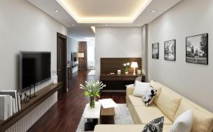 uma sala de estar com um sofá e uma televisão em Eco Luxury Hotel Hanoi em Hanói