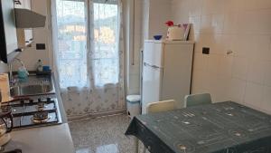 a kitchen with a refrigerator and a table and a sink at Margin - Appartamento vicino al centro in Genoa