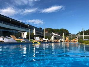 a large swimming pool with chairs and a building at L57_resort in Gródek Nad Dunajcem