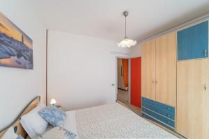 a bedroom with a bed and a blue cabinet at Residenza Puerto Do Sol in Lignano Sabbiadoro