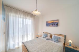 a bedroom with a bed and a large window at Residenza Puerto Do Sol in Lignano Sabbiadoro