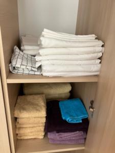 um armário com toalhas e toalhas dobradas em Holiday Apartments 4 Bozhurets Kavarna Bulgaria em Bozhurets