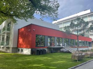 un bâtiment rouge avec une pelouse verte devant lui dans l'établissement Esplanaadi 10 LUX Apartment, à Pärnu