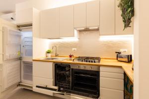 eine Küche mit weißen Schränken und einem Herd mit Backofen in der Unterkunft Brenta Top Floor - MM3 Yellow Line in Mailand