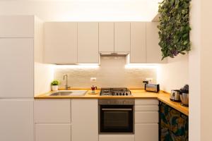 eine Küche mit weißen Schränken und einer Spüle in der Unterkunft Brenta Top Floor - MM3 Yellow Line in Mailand