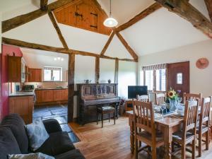 a living room with a table and a dining room at Y Dderwen in Pen-y-bont-fawr