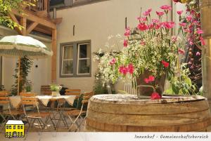 a patio with a table and flowers in a barrel at Das Gelbe Haus - Drei besondere Ferienwohnungen in Flensburg