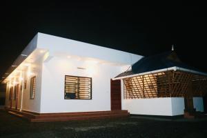 a white house with a black roof at night at VAGAMON VAGADROPS in Vagamon