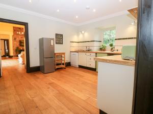 uma cozinha com armários brancos e um frigorífico em The Old Laundry Cottage em Perth