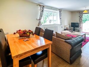 a living room with a wooden table and a couch at Woodside Fishery - Kingfisher in Cleobury Mortimer