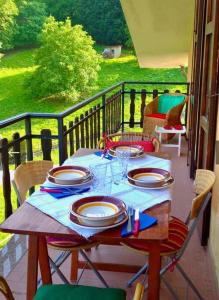 a table with plates and glasses on a balcony at Appartamento panoramico Casa Gerro in Averara