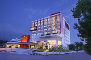 a large building with a restaurant in front of it at Hotel Santika Palu in Palu