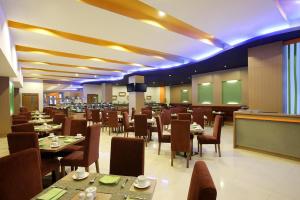 a dining room with tables and chairs in a restaurant at Hotel Santika Palu in Palu