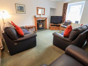 a living room with two leather couches and a television at 7 Stybarrow Terrace in Penrith