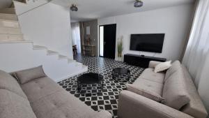 a living room with a couch and a television at Delta House - Alfa apartment in Zadar