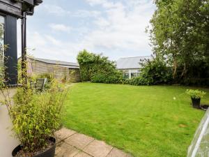 a garden with a large lawn in front of a house at Fernleigh Villa Annexe in Wisbech