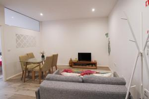 uma sala de estar com um sofá e uma mesa em 2 Bedroom Cosy Flat em Porto