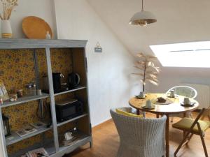 una mesa y sillas en una habitación con cocina en Grande Chambre Familiale JAUNE Tout Bonnement Bien, en Putot-en-Auge