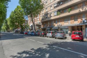 波隆那的住宿－Bologna Rimesse & Ospedale Sant'Orsola Apartment，一条在大楼前停放汽车的街道