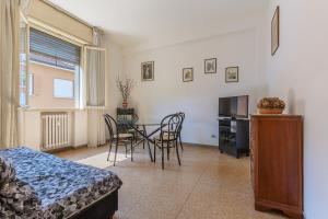 um quarto com uma mesa e cadeiras e uma televisão em Bologna Rimesse & Ospedale Sant'Orsola Apartment em Bolonha