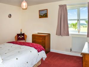 a bedroom with a bed and a window at The Old Byre in Haswell