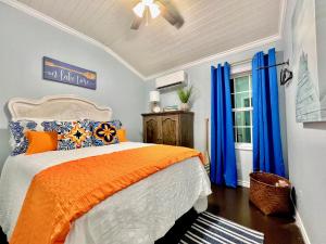 a bedroom with an orange bed and blue curtains at SLEEPS SIX - Rent Entire WATERFRONT CABIN #1 