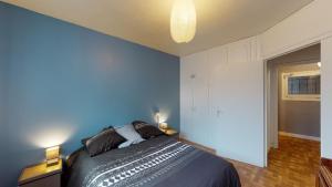 Schlafzimmer mit einem Bett mit blauer Wand in der Unterkunft L'Episcopale - Maison 2 chambres in Albi