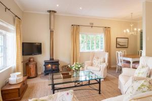 a living room with a fireplace and a table at Chambery in Cape Town