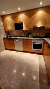 a large kitchen with wooden cabinets and a sink at Jardines de Nueva Galera en Estepona in Estepona +16 photos
